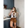 Mulher tomando café na cozinha, vestindo pijama baby doll com estampa do Harry Potter e personagens da saga