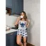 Mulher usando pijama feminino do Stitch em ambiente de cozinha, segurando uma xícara de café