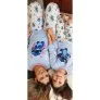 Mãe e filha deitadas usando pijama longo azul do Stitch combinando, estampado com desenhos do personagem